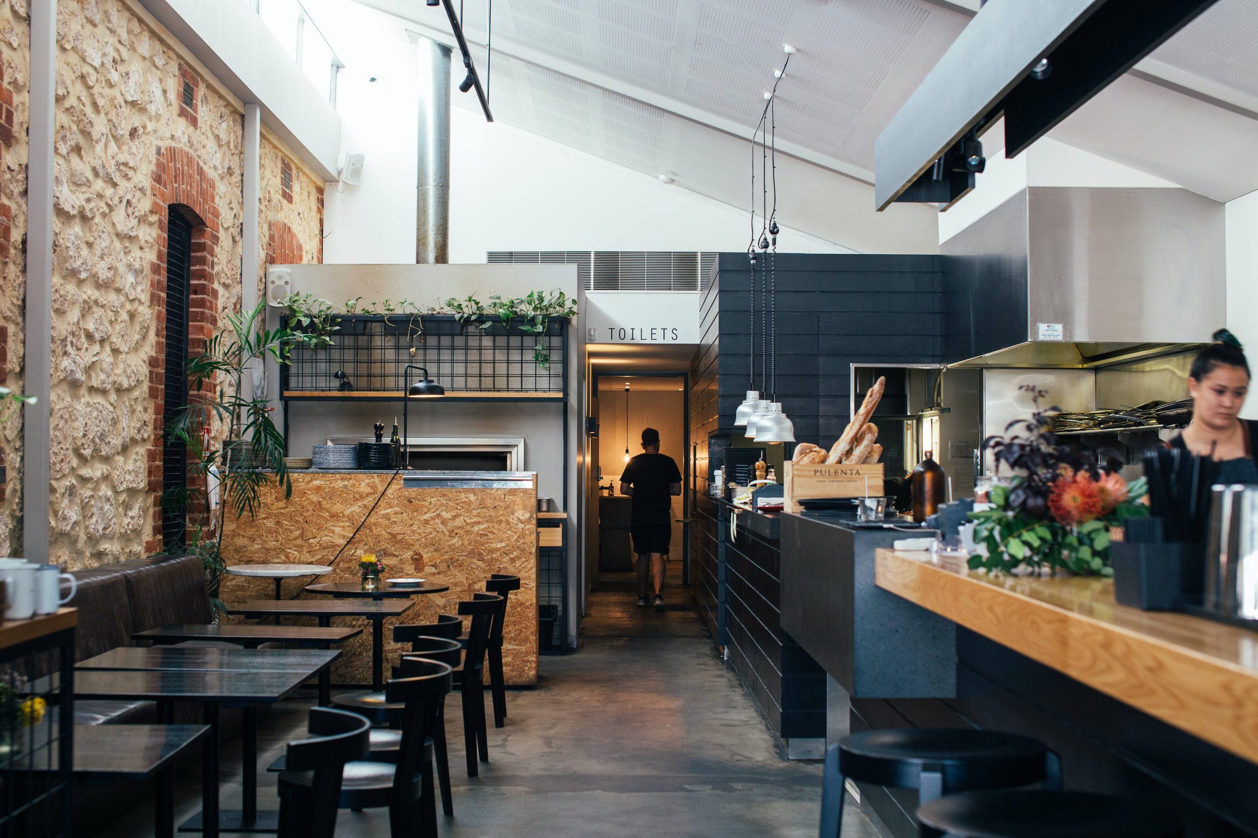 Restaurant space with open kitchen and seating.