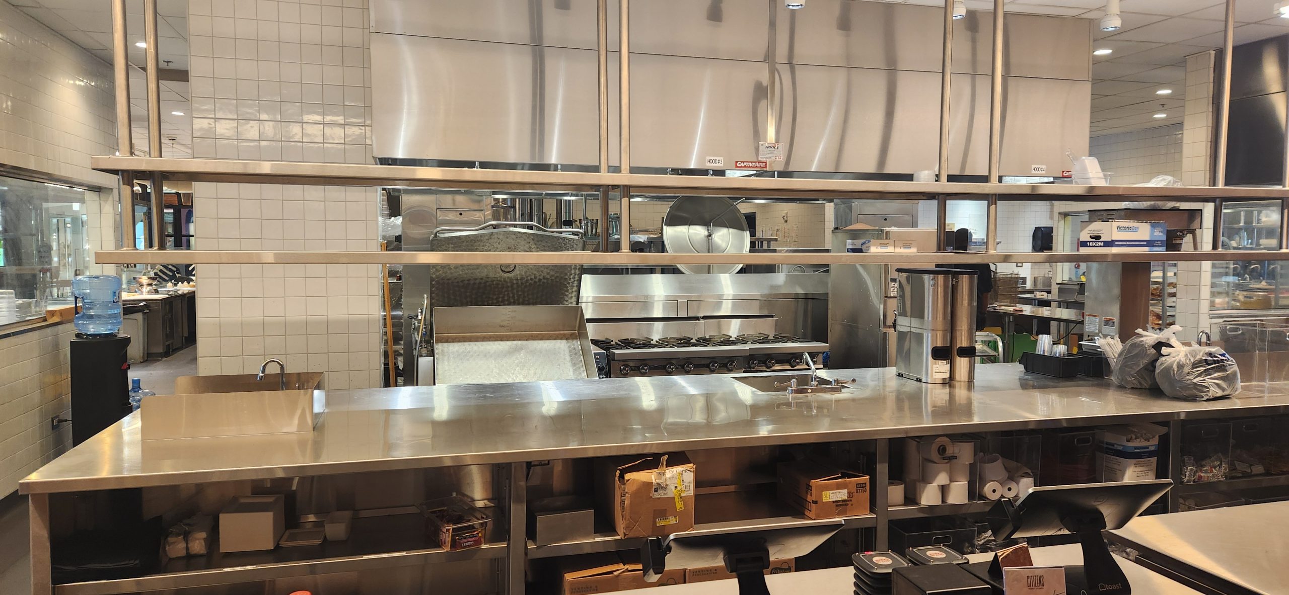 Commercial Kitchen set up with large hood, tilt skillet, cook and hold ovens, convection ovens, refrigeration and stove burners. Opportunity for chefs and restaurant owners