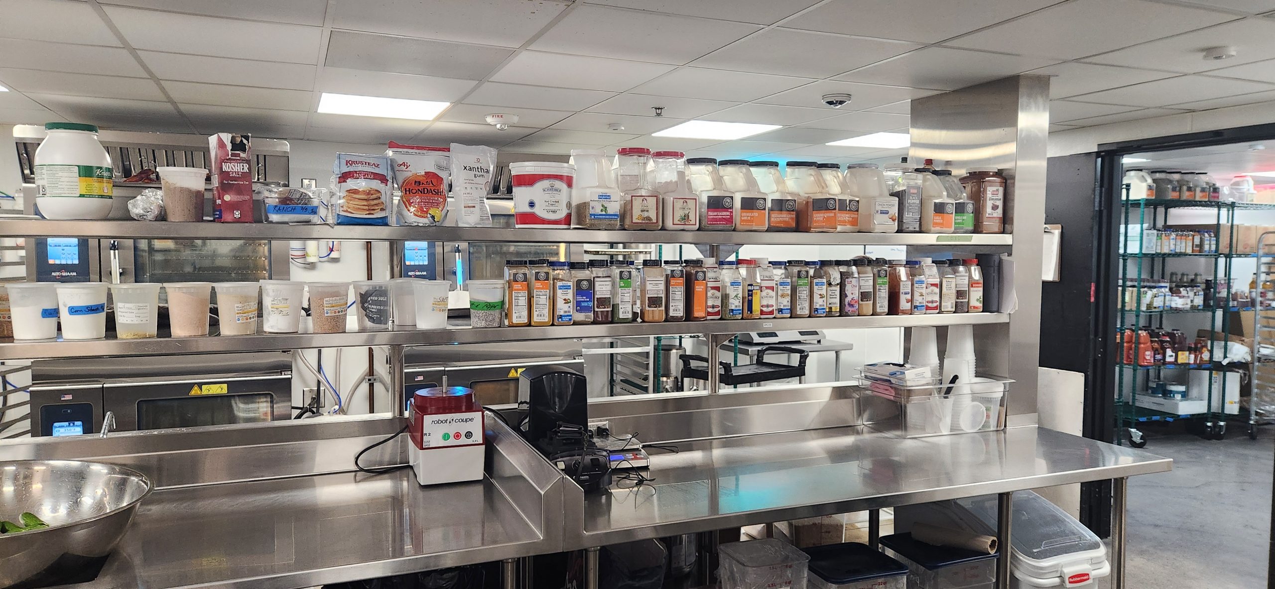 Commercial Kitchen Prep area with mixers, spices and other commercial cooking utensils.