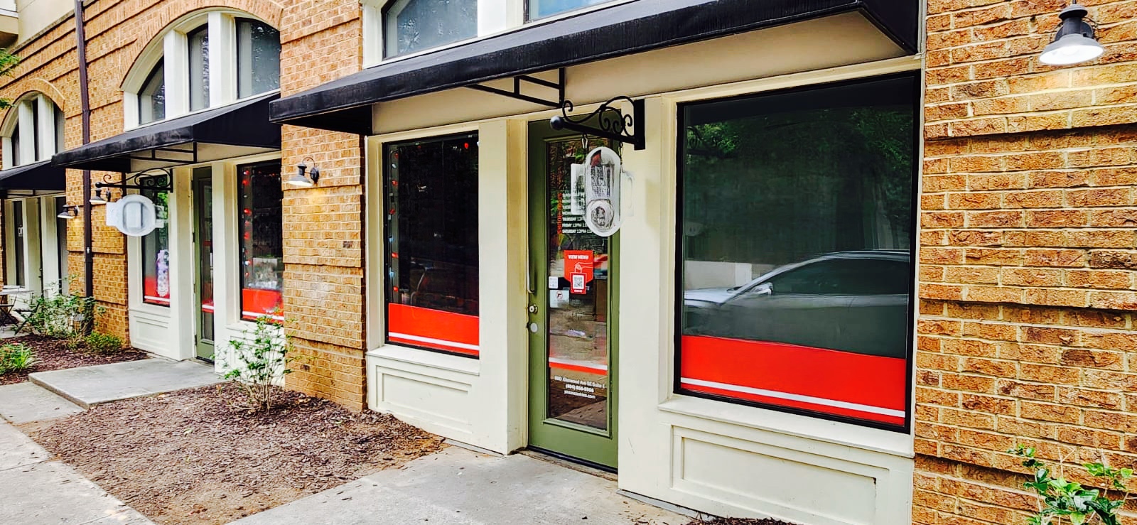 Store front with windows, main door and exposed brick walls