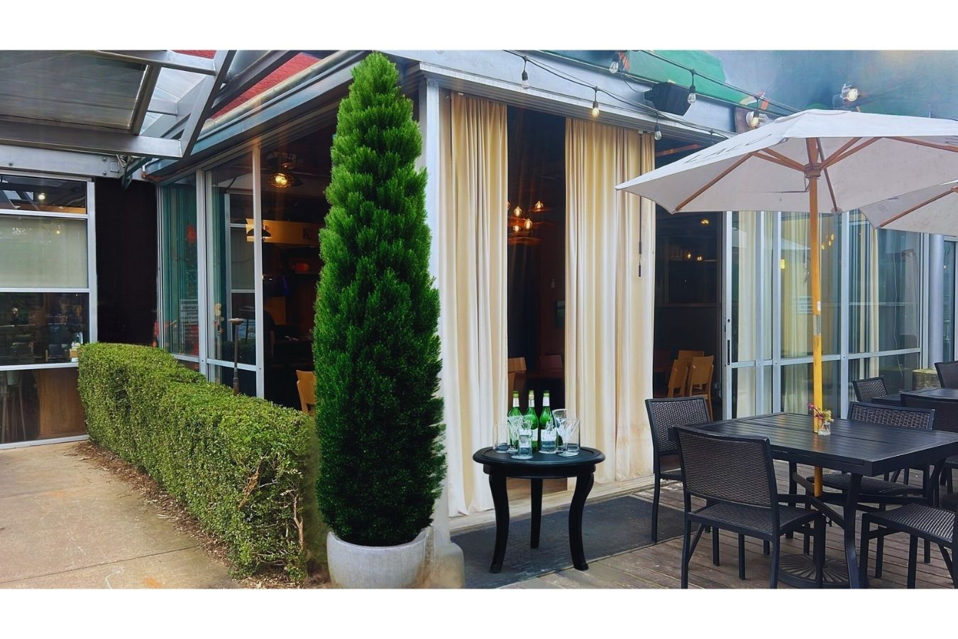 Outdoor patio dining area at a turnkey restaurant for sale in Decatur, GA — presented by Jimmy Carey Commercial Real Estate. Features shaded seating, natural greenery, and excellent street visibility in a high-traffic corridor.